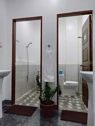 a bathroom with a shower and a sink and a toilet at Fil-Can Hostel Coron in Coron