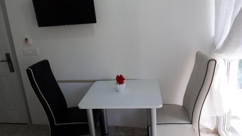 a white table with chairs and a vase on it at Apartments Ohrid Lake in Ohrid