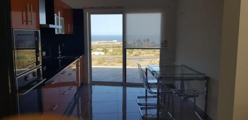 uma cozinha com uma mesa de vidro e vista para o oceano em CASA MIRAMAR FRONTERA em Frontera