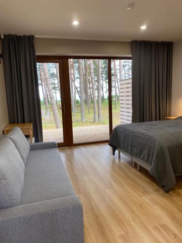 ValgerannaにあるValgeranna puhkekeskuse hotellのベッドルーム1室(ベッド1台、ソファ、窓付)