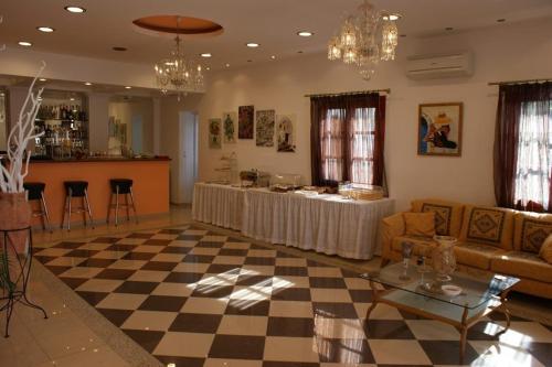 een woonkamer met een tafel en een dambord vloer bij Annita's Village Hotel in Agia Anna Naxos