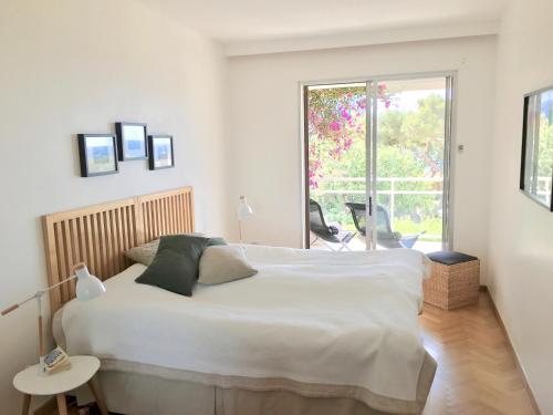 une chambre avec un grand lit blanc et une fenêtre dans l'établissement Super Bestouan, à Cassis