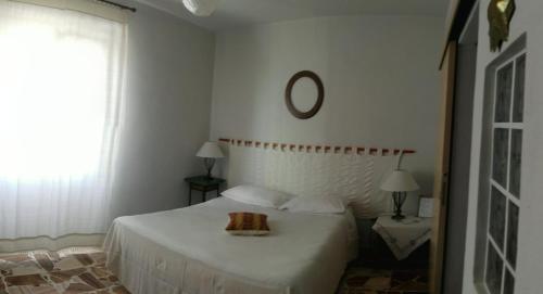 - une chambre blanche avec un lit et un miroir dans l'établissement Pà Blanc B&B, à Alghero
