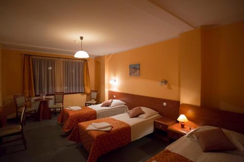 スタルガルトにあるHotel Spichlerzのベッド2台とテーブルが備わるホテルルームです。