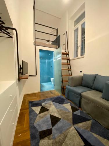 a living room with a couch and a staircase at Il cortile di Elen in Marsala