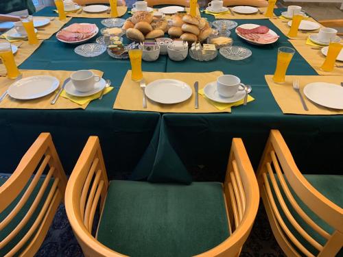 a long table with chairs and plates of food at Antik Hotel Sofia in Litomyšl