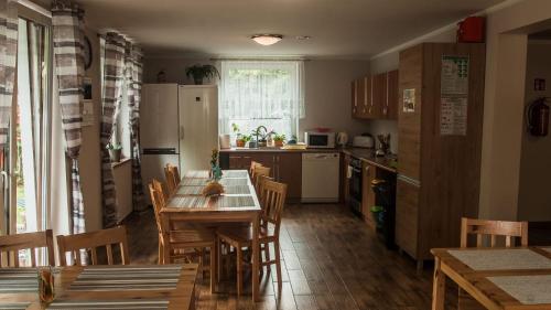 uma cozinha com uma mesa e cadeiras e um frigorífico em Sieraton Pokoje i Apartament em Stronie Śląskie