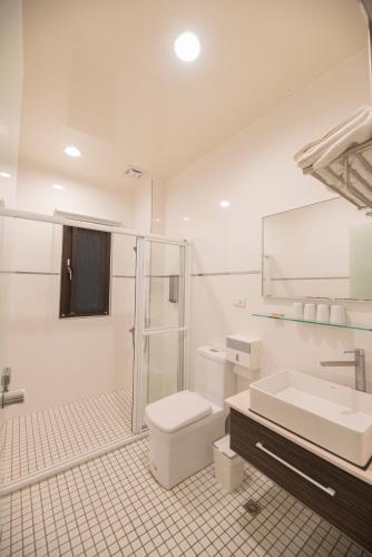 a bathroom with a toilet and a sink and a shower at 澎湖夏日南風民宿 in Magong