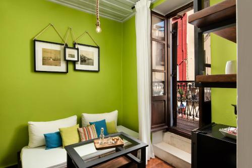 a living room with green walls and a couch at Favela Living Space in Chania