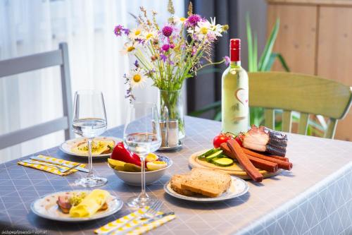 a table with plates of food and a bottle of wine at Apartment Brigitte in Obertraun
