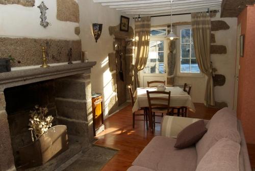 a living room with a fireplace and a dining room at Le gîte d'Etienne in Joué-du-Bois