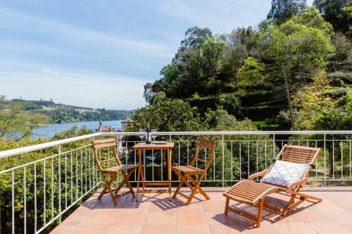 a patio with two chairs and a table on a balcony at Quinta da Agraceira Casa do Caseiro in Vila Nova de Gaia