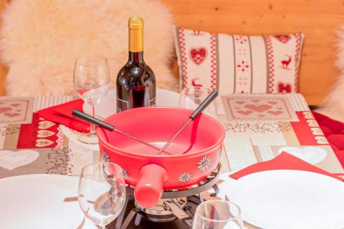 a table with a pink pot and a bottle of wine at Wasserfallhüsli in Lauterbrunnen, near Interlaken, Mürren, Wengen in Lauterbrunnen