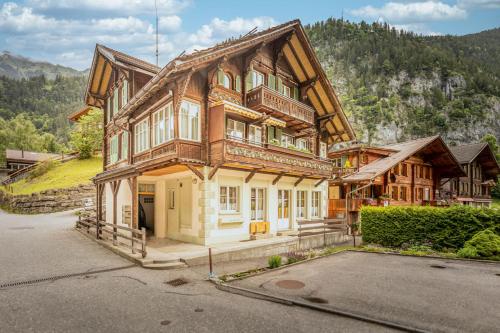 a large wooden house on top of a mountain at Wasserfallhüsli in Lauterbrunnen, near Interlaken, Mürren, Wengen in Lauterbrunnen