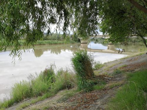 a body of water with a bridge in the background at Pensiunea Casa Matei in Berca