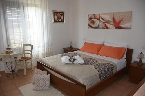 ein Schlafzimmer mit einem Bett mit orangefarbenen Kissen in der Unterkunft Bed and Breakfast Le petunie in Bari Sardo