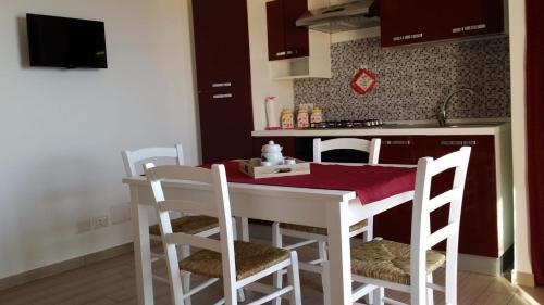 cocina con mesa blanca y sillas en una habitación en DEA DEL BORGO, en SantʼAmbrogio