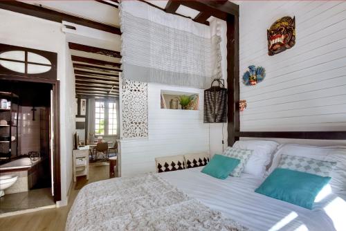 een slaapkamer met een groot wit bed met blauwe kussens bij Le cocon Bourbonnoux in Bourges