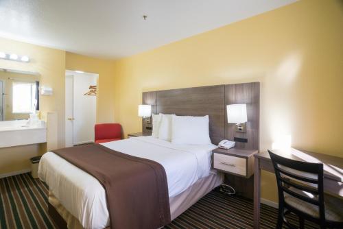 a hotel room with a large bed and a desk at Beachview Inn in Santa Cruz