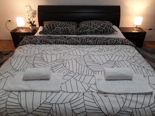 a black and white bed with two pillows on it at Private Home Rifat in Dubrave Gornje