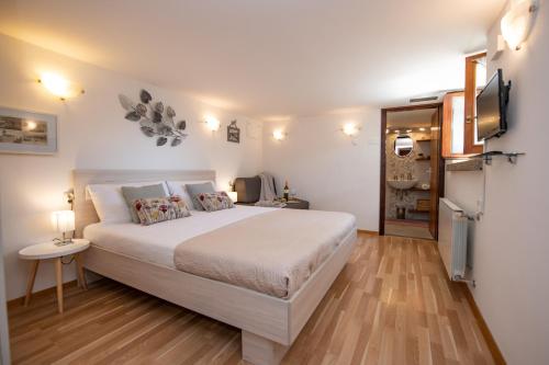 a bedroom with a large white bed and a television at Apartment Amalia Volosko in Opatija