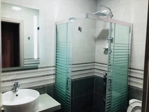 La salle de bains est pourvue d'un lavabo et d'une douche en verre. dans l'établissement Angela Apartments, à Fanárion