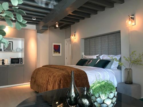 a bedroom with a large bed and a glass table at Suite Londen66 in Den Bosch