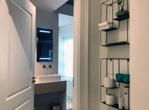 a bathroom with a sink and a mirror at Suite Londen66 in Den Bosch