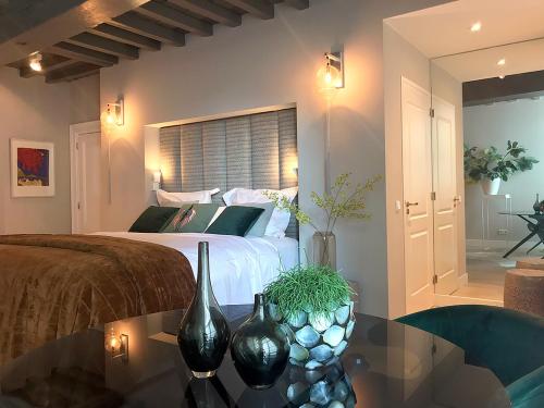 una camera da letto con un letto e un tavolo con vasi sopra di Suite Londen66 a Den Bosch