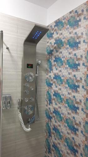 a shower in a bathroom with a tile wall at GP Apart SeaView, Mamaia Nord in Mamaia Sat/Năvodari