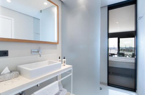a bathroom with a sink, toilet and bathtub at The Suites Rainvilleterrasse in Hamburg