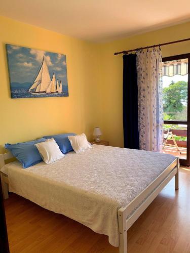 a bedroom with a large bed with a sail boat on the wall at Apartments Vidakovic in Ugljan