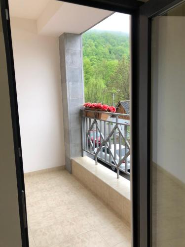 einen Balkon mit einem Fenster mit roten Blumen. in der Unterkunft Bel Apart in Dilidschan