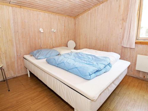 een bed in een kamer met houten wanden bij Holiday Home Kongeørnen in Odde