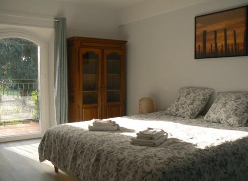 a bedroom with a bed with towels on it at Maison calme au cœur des vignes in Sainte-Colombe