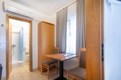 a room with a table and chairs and a bathroom at Apartmaji pri Perotu in Izola