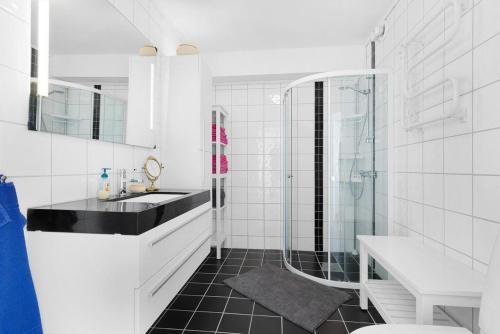 a white bathroom with a sink and a shower at Seaside Holiday Home, great for fishing & hiking in Hellesøyni