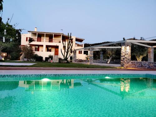 uma grande piscina em frente a uma casa em Holiday Rooms em Otziás