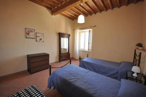 a bedroom with a blue bed and a dresser at Casa dei canali, sulla piazza del paese in Capoliveri