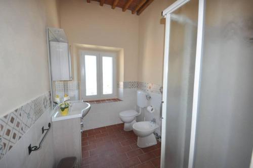a bathroom with a toilet and a sink and a shower at Casa dei canali, sulla piazza del paese in Capoliveri