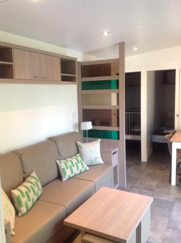 un salon avec un canapé et une table dans l'établissement TopSun Argelès la Sirène Cottage3 40m2 Max 4 adultes et 2 des ses enfants inc bebe, à Argelès-sur-Mer