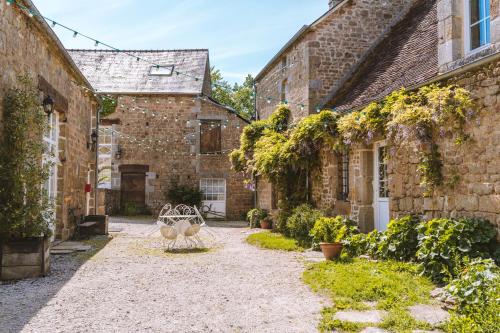 a courtyard of an old stone building with a bench at Le gîte d'Etienne in Joué-du-Bois