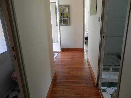 a hallway with wooden floors and a mirror at Au pré du Mignon aux portes du Marais Poitevin in Thorigny