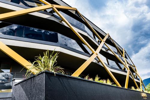 a building with yellow and black facade with plants at Genusshotel Diamant in Naturno