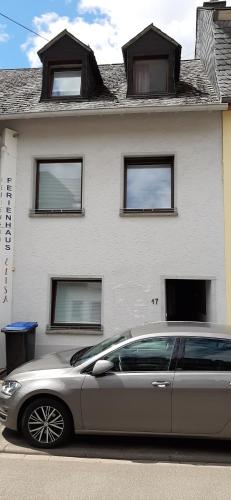 a silver car parked in front of a white house at Ferienhaus Elisa in Trittenheim
