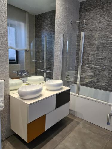 uma casa de banho com 2 lavatórios e um chuveiro em Casa do Negrões em Boticas