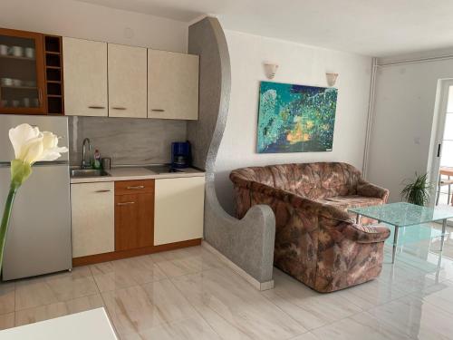 Il comprend un salon avec une chaise et une cuisine. dans l'établissement Apartman Kartec, à Krk