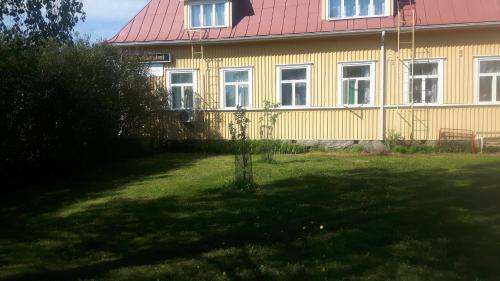 uma casa amarela com um telhado vermelho em Asemantupa 2 em Pyhäsalmi