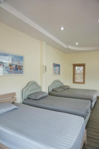 a bedroom with three beds in a room at Oriental Beach By Winnie in Cha Am