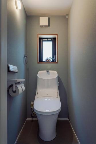 a bathroom with a toilet and a window at HOUS-AGALonomichi in Onomichi